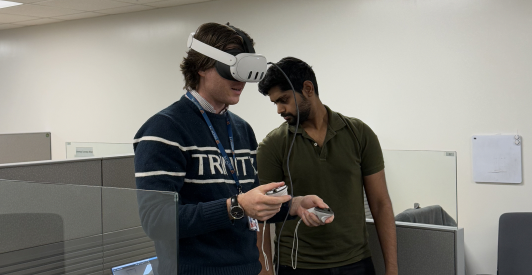 A student wearing an MR headset stands beside a facilitator during a usability session.